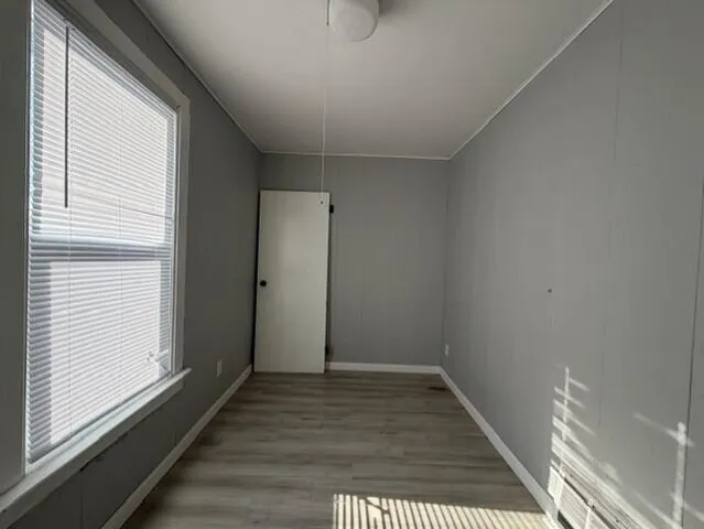 an empty room with a window and closet