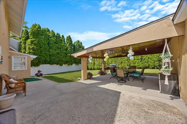 a view of a patio with a table and chairs under an umbrella