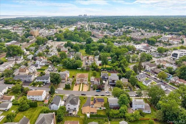 an aerial view of residential houses with outdoor space and trees