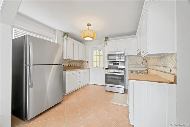 a kitchen with stainless steel appliances a refrigerator and a stove top oven