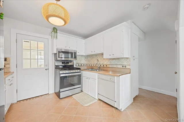 a kitchen with a stove cabinets and window