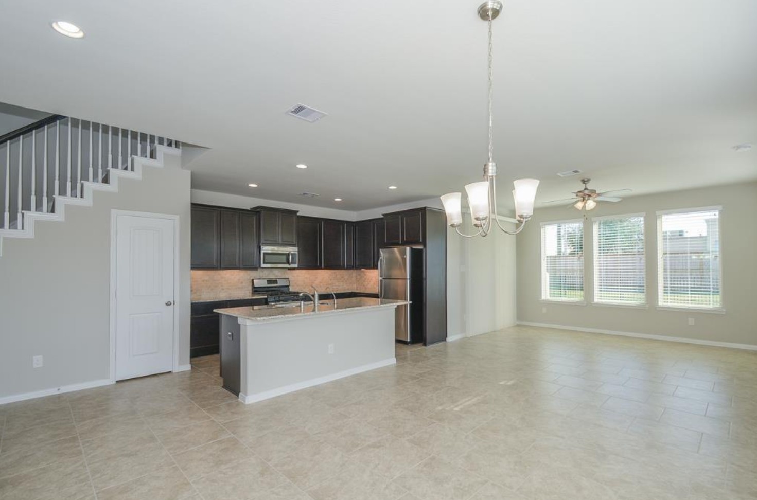 3306 Rainflower Springs Lane Rosenberg, TX 77471 - Photo 4 of 18 a kitchen with kitchen island a sink and a large window