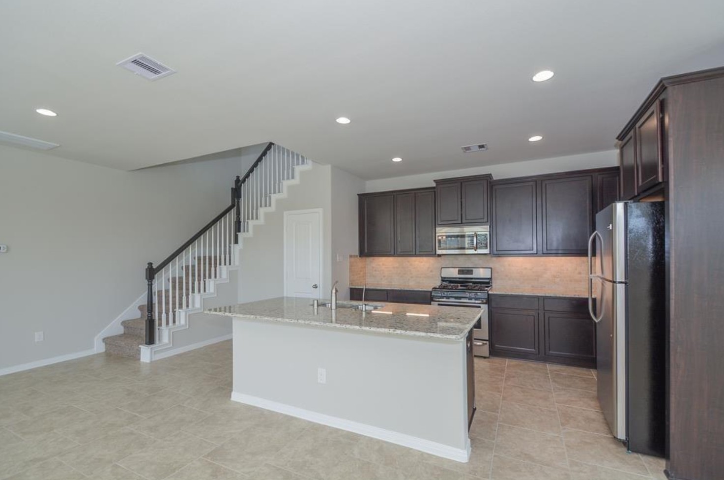 3306 Rainflower Springs Lane Rosenberg, TX 77471 - Photo 6 of 18 a kitchen with kitchen island a sink stainless steel appliances and cabinets