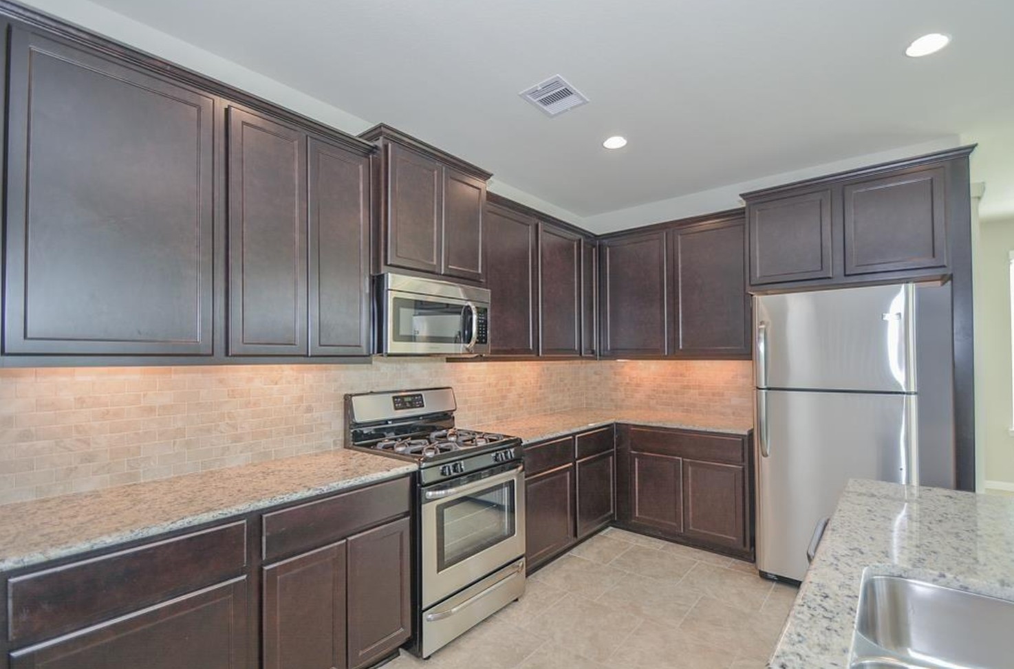 3306 Rainflower Springs Lane Rosenberg, TX 77471 - Photo 8 of 18 a kitchen with a sink a refrigerator and cabinets