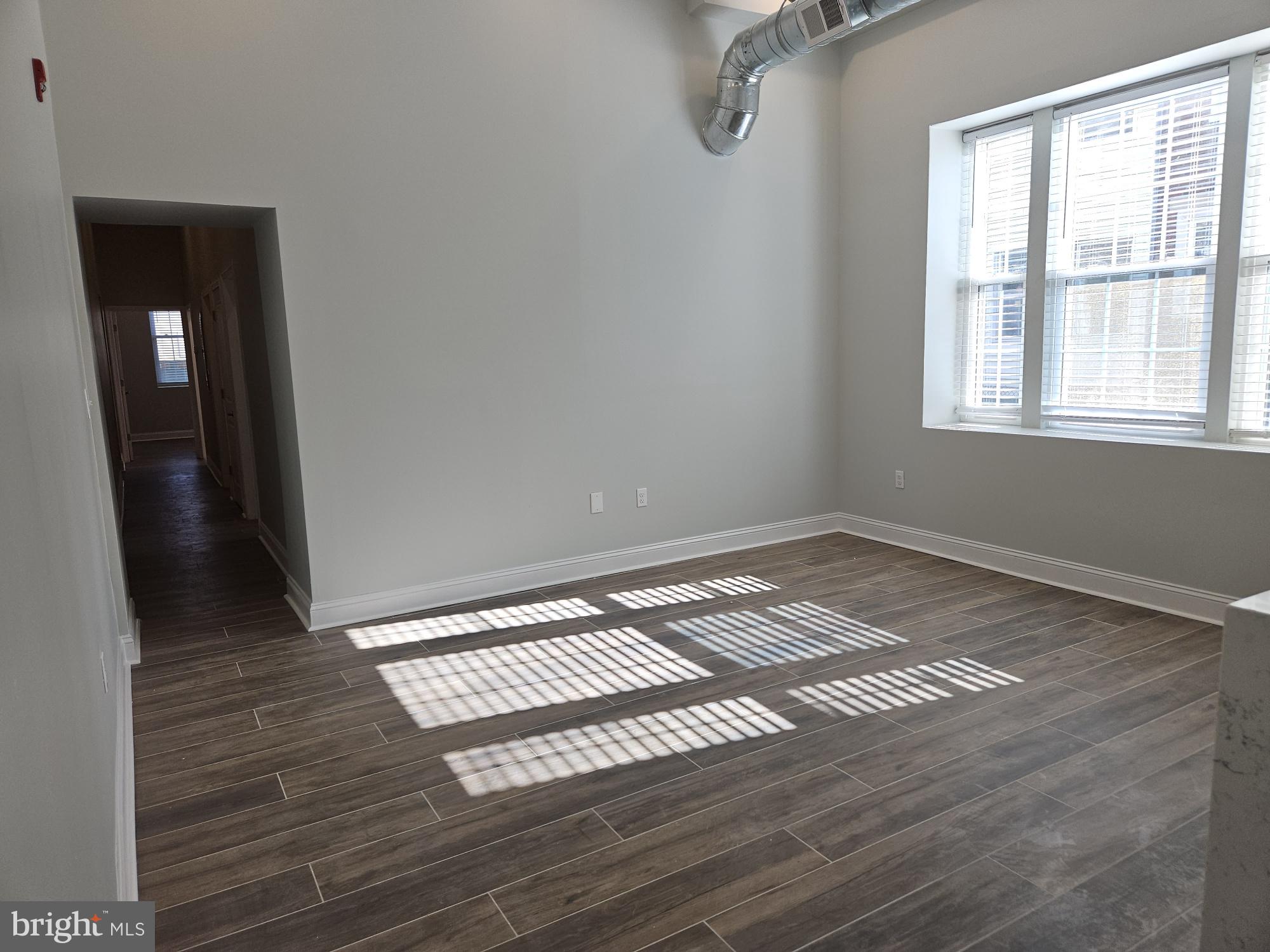 59 High Street, Unit A Philadelphia, PA 19144 - Photo 17 of 26 a view of an empty room with wooden floor and a window