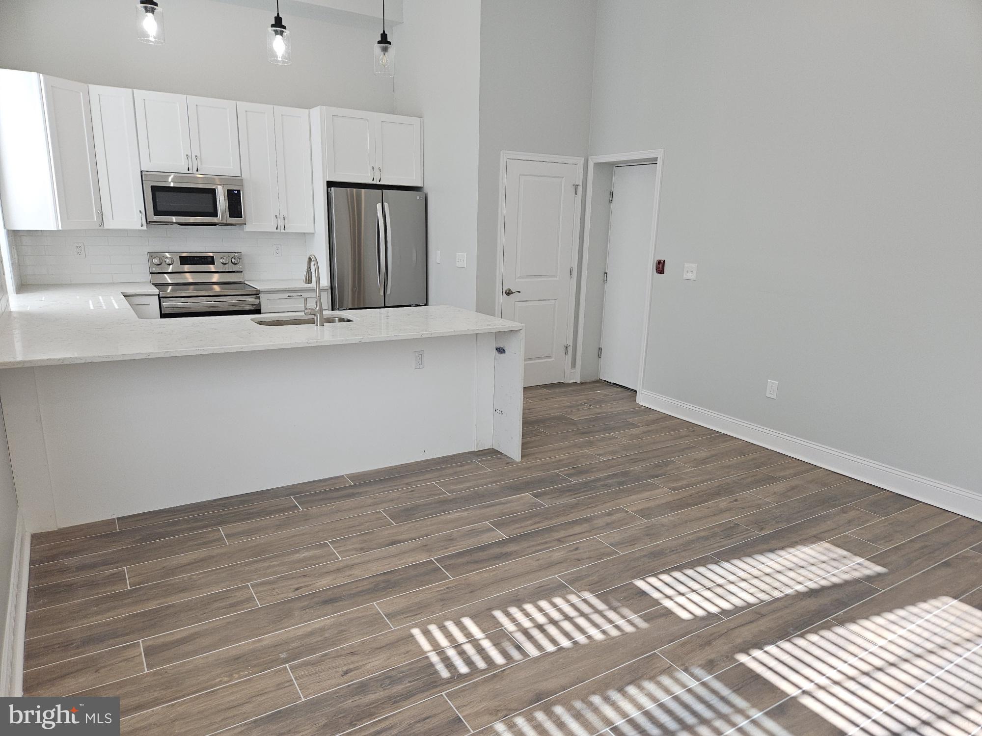 59 High Street, Unit A Philadelphia, PA 19144 - Photo 2 of 26 a kitchen with stainless steel appliances a refrigerator microwave and sink