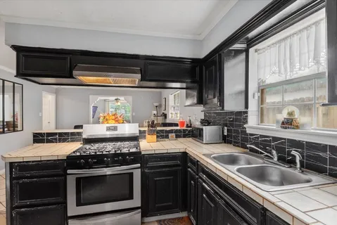 a kitchen with stainless steel appliances granite countertop a stove and a sink