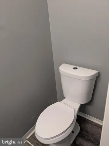 a white toilet sitting next to a white wall