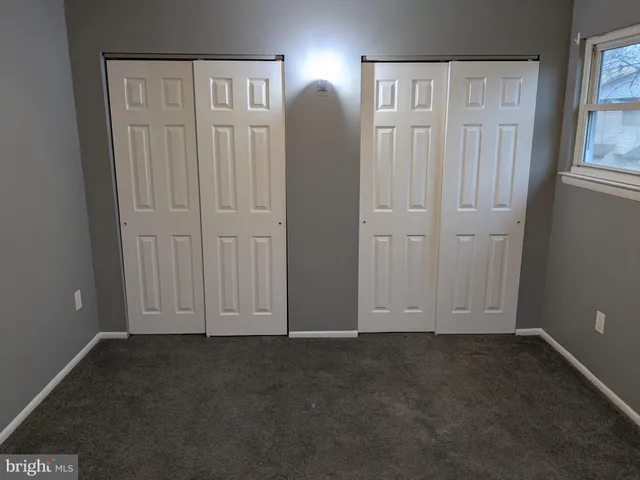 an empty room with windows and closet