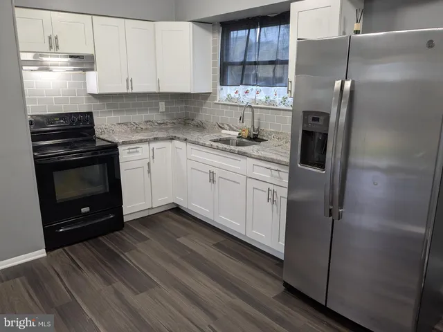 a kitchen with a refrigerator sink and cabinets