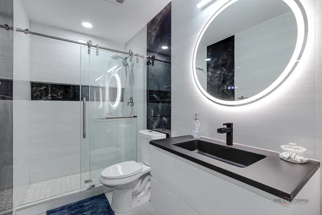 a bathroom with a toilet a sink and mirror