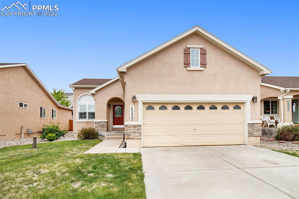 14229 Petrel Drive Colorado Springs, CO 80921 - Photo 1 of 19 a view of a white house with a yard and plants
