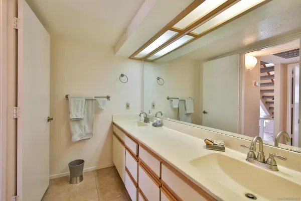 a bathroom with a double vanity sink a mirror and shower