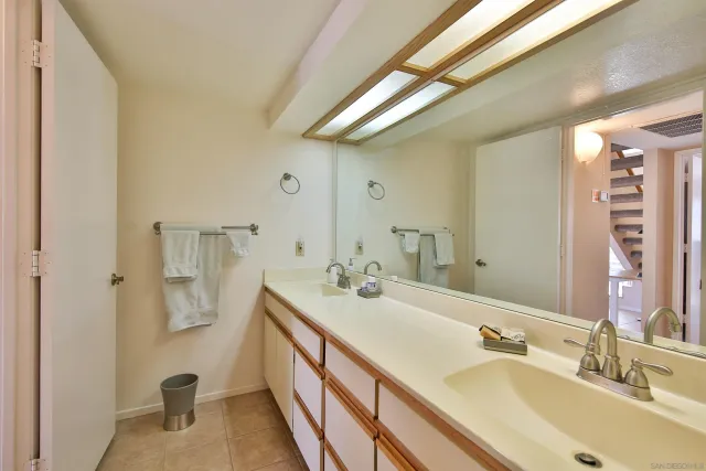a bathroom with a double vanity sink a mirror and shower