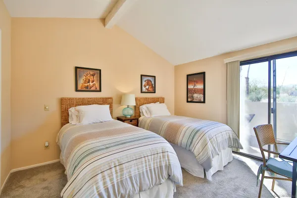 a bedroom with two beds and a large window