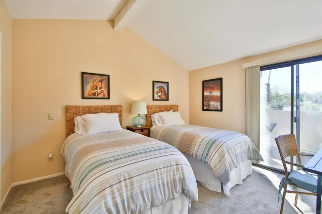 a bedroom with two beds and a large window