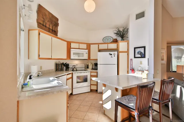 a kitchen with a table chairs refrigerator and cabinets