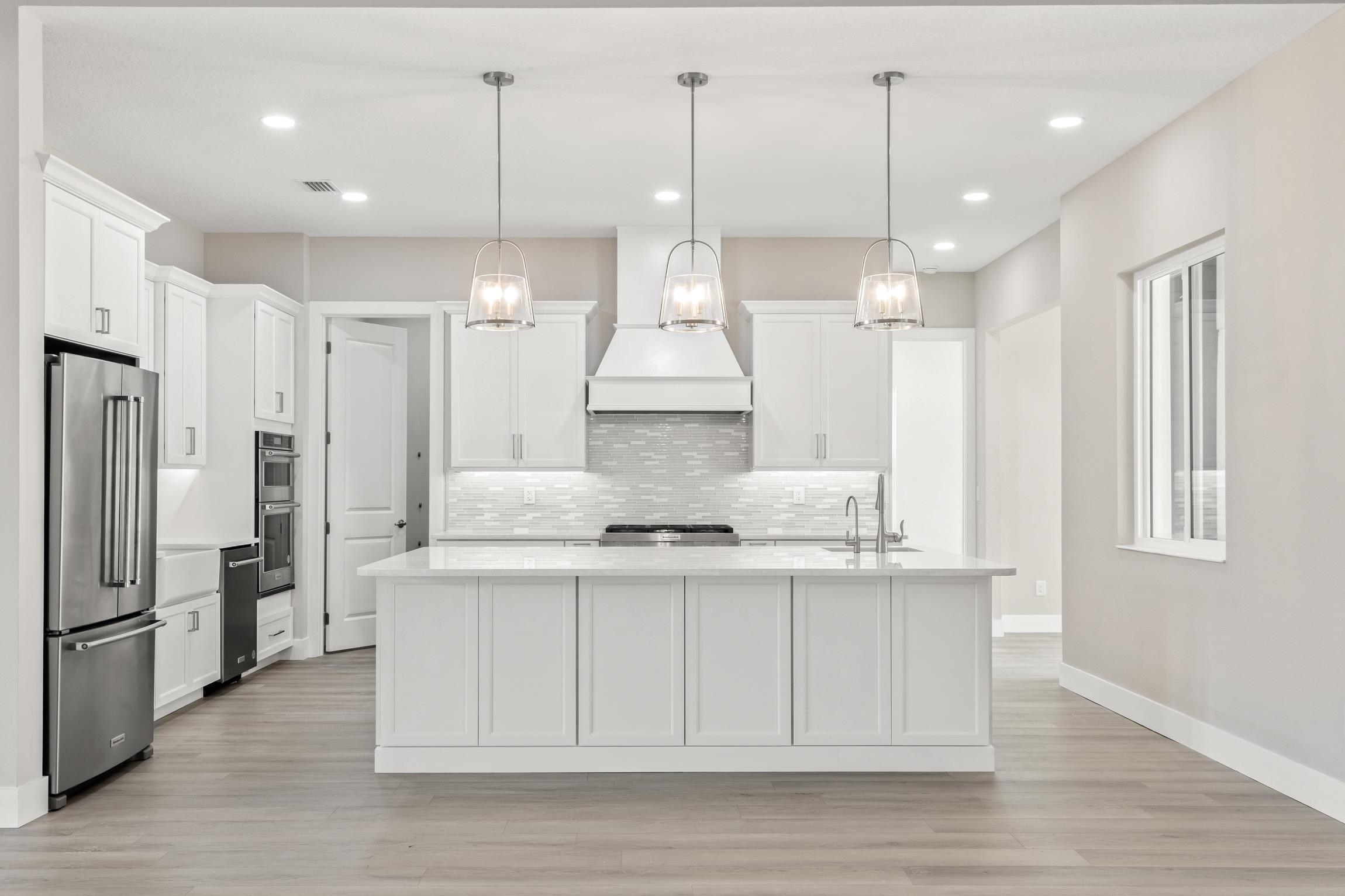 129 16th Street St. Augustine, FL 32080 - Photo 11 of 34 a kitchen with stainless steel appliances granite countertop wooden floors sink and cabinets