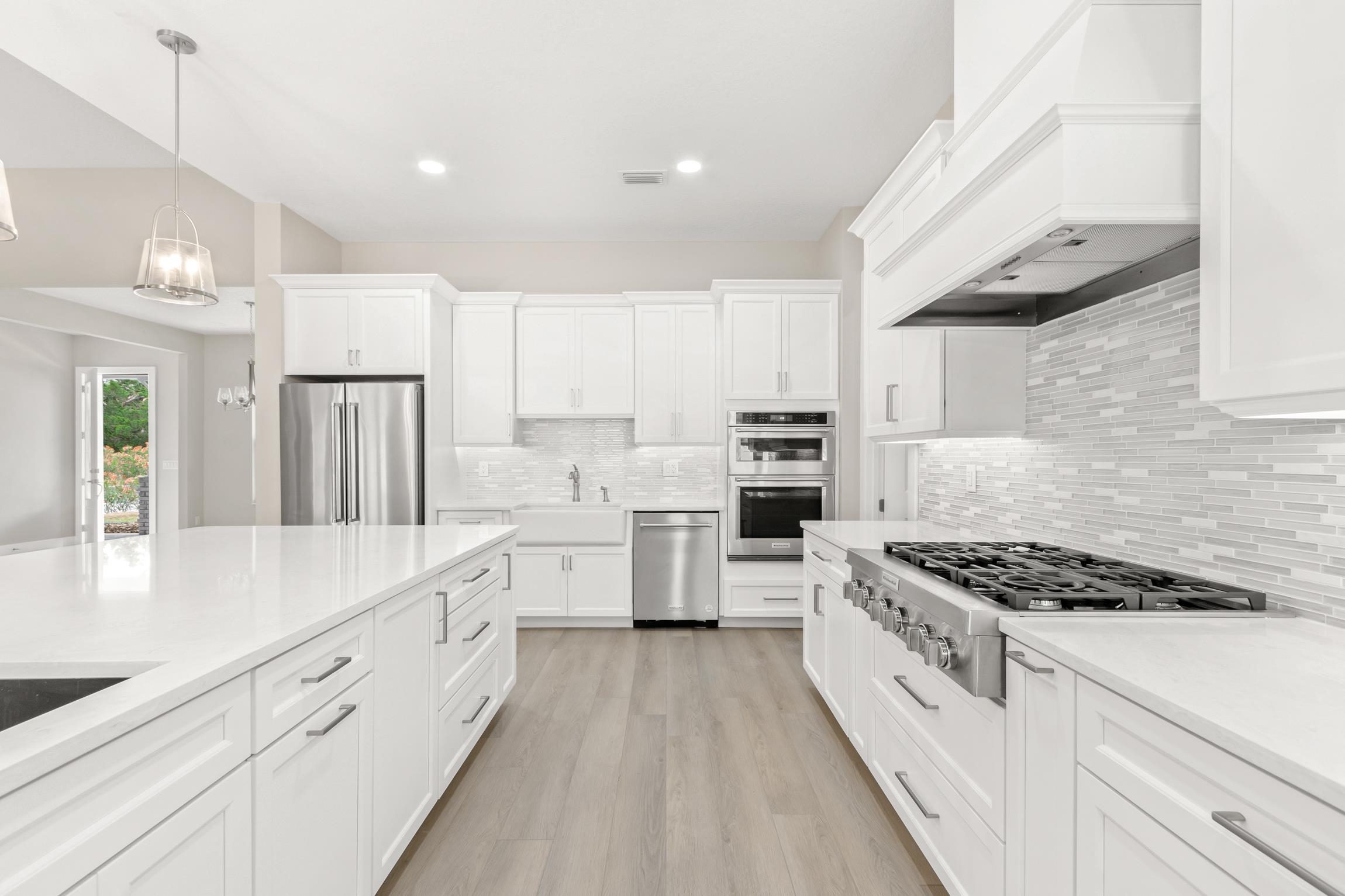 129 16th Street St. Augustine, FL 32080 - Photo 14 of 34 a large kitchen with white cabinets and stainless steel appliances