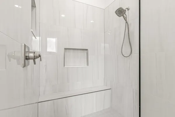 a spacious bedroom with a large window and a ceiling fan