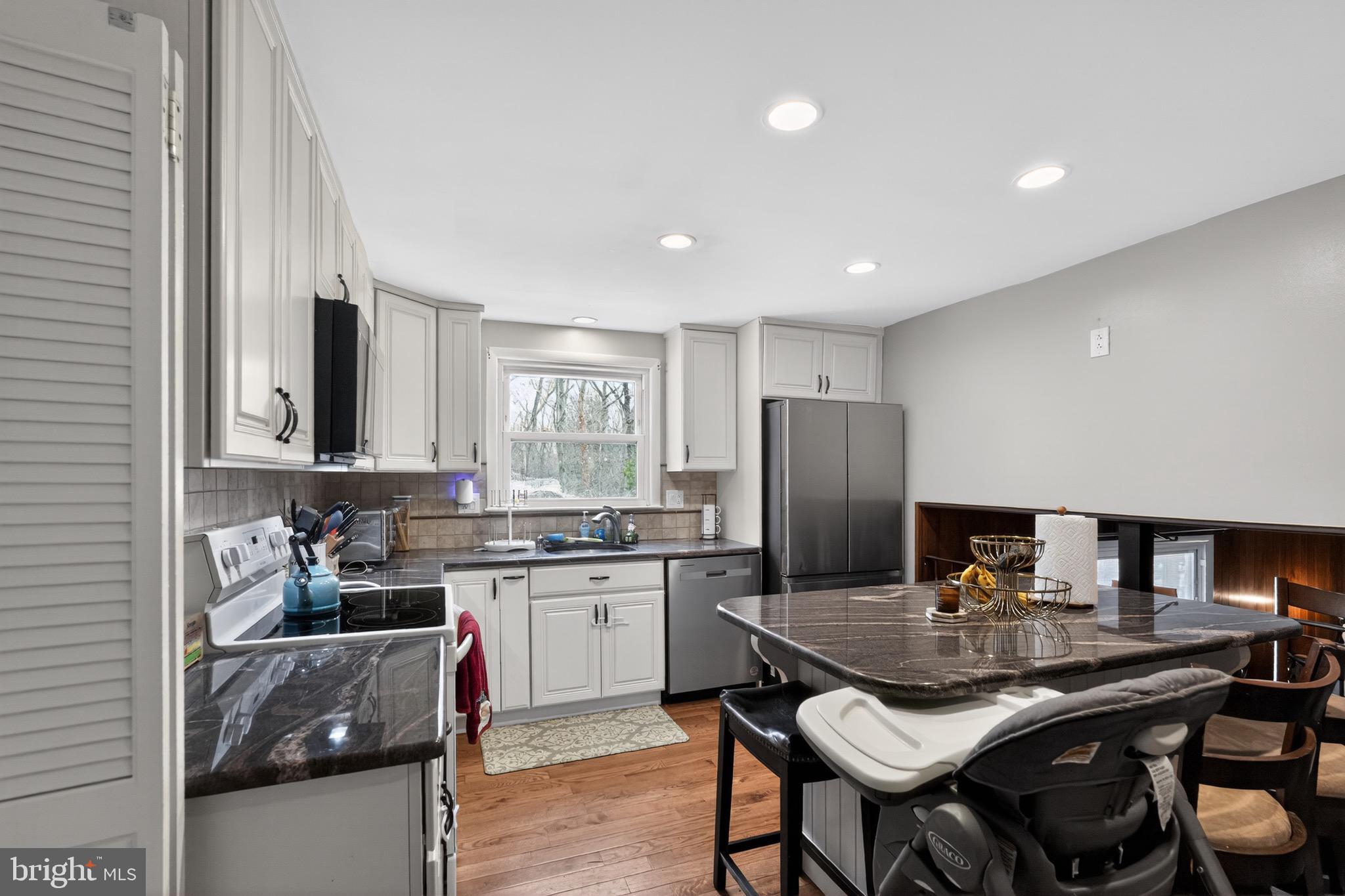 4517 East Yates Road Bensalem, PA 19020 - Photo 2 of 23 a kitchen with stainless steel appliances granite countertop a stove a refrigerator a sink a dining table and chairs