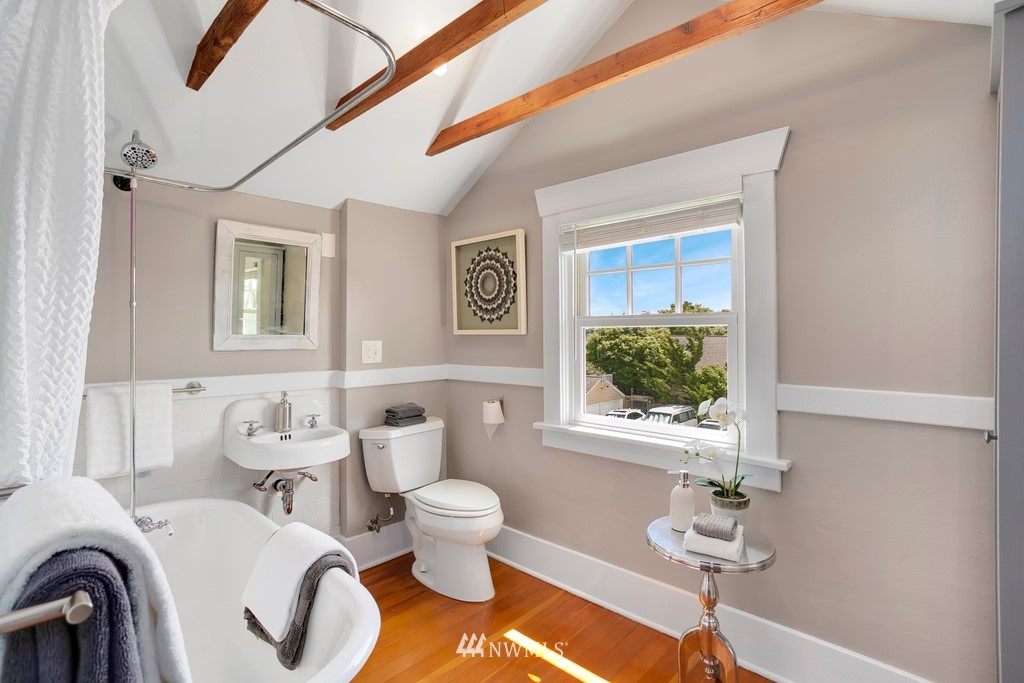 767 North 75th Street Seattle, WA 98103 - Photo 12 of 25 a bathroom with a toilet sink and mirror