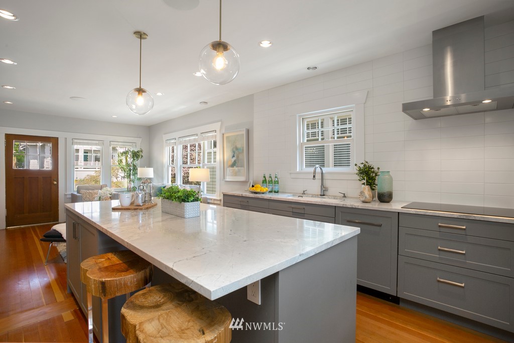 767 North 75th Street Seattle, WA 98103 - Photo 6 of 25 a large kitchen with kitchen island a stove a table and chairs in it