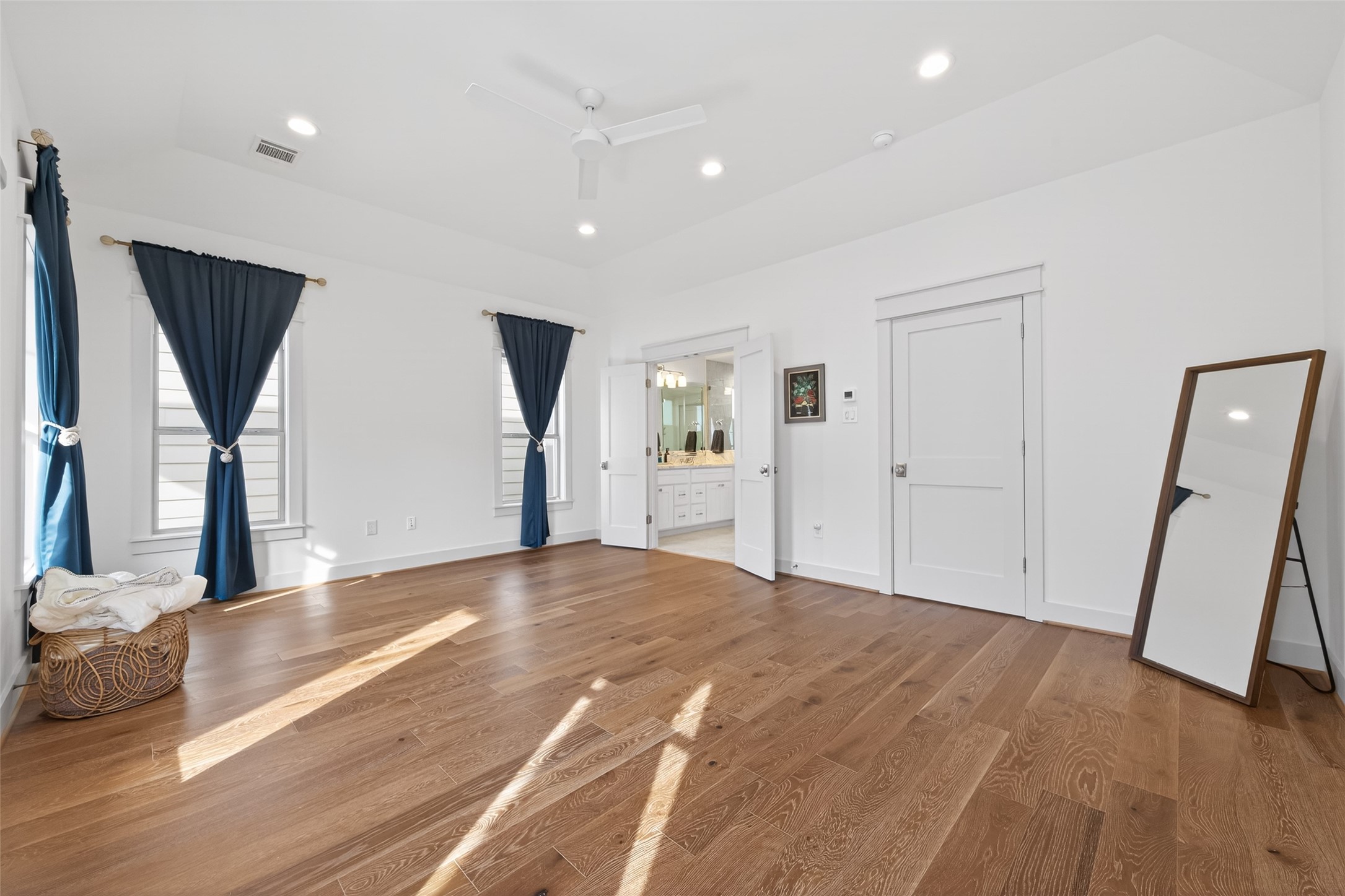 515 West 25th Street Houston, TX 77008 - Photo 16 of 35 Spacious 18’4” x 14’2” primary bedroom features a Minka-Aire large-room fan in flat white and an 11’1” x 8’7” walk-in closet with built-in shelving, cubbies, and hanging racks.