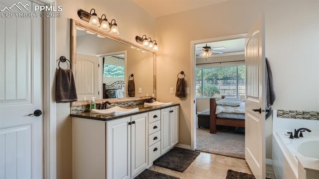 1118 Spectrum Loop Colorado Springs, CO 80921 - Photo 13 of 30 a spacious bathroom with a double vanity sink a mirror and a shower