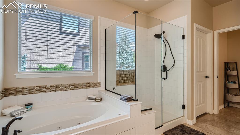 1118 Spectrum Loop Colorado Springs, CO 80921 - Photo 14 of 30 a bathroom with a bathtub and a shower