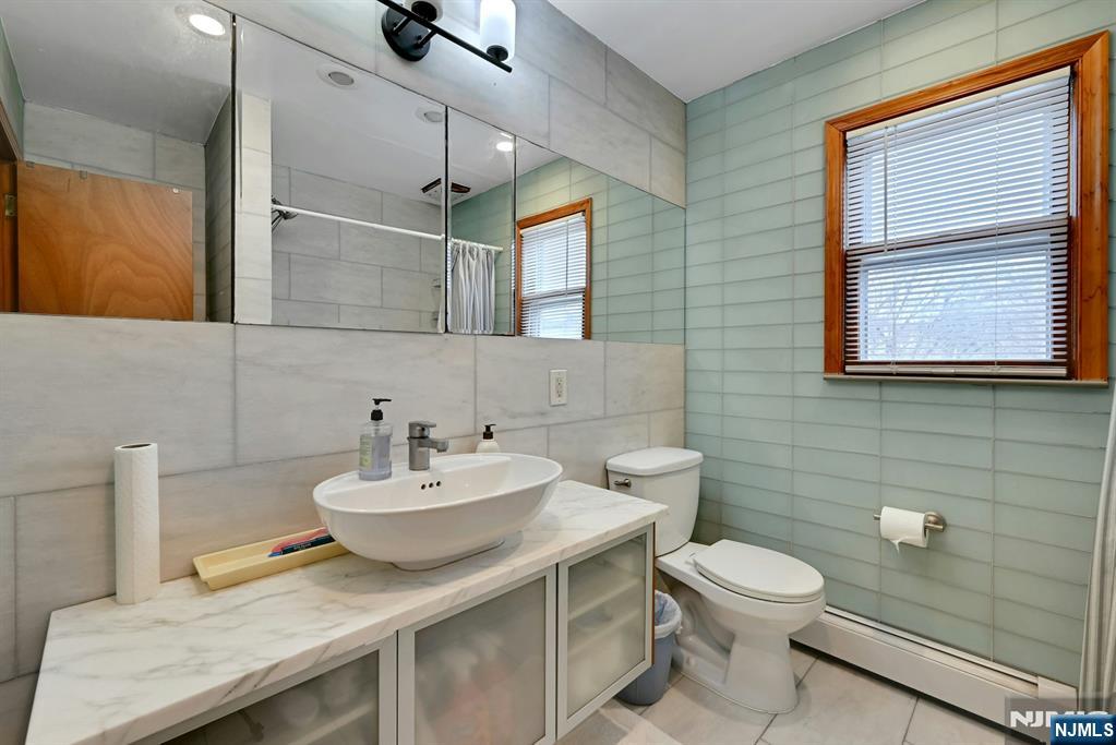 68 Bergen Turnpike Ridgefield Park, NJ 07660 - Photo 13 of 35 a bathroom with a sink a toilet and mirror