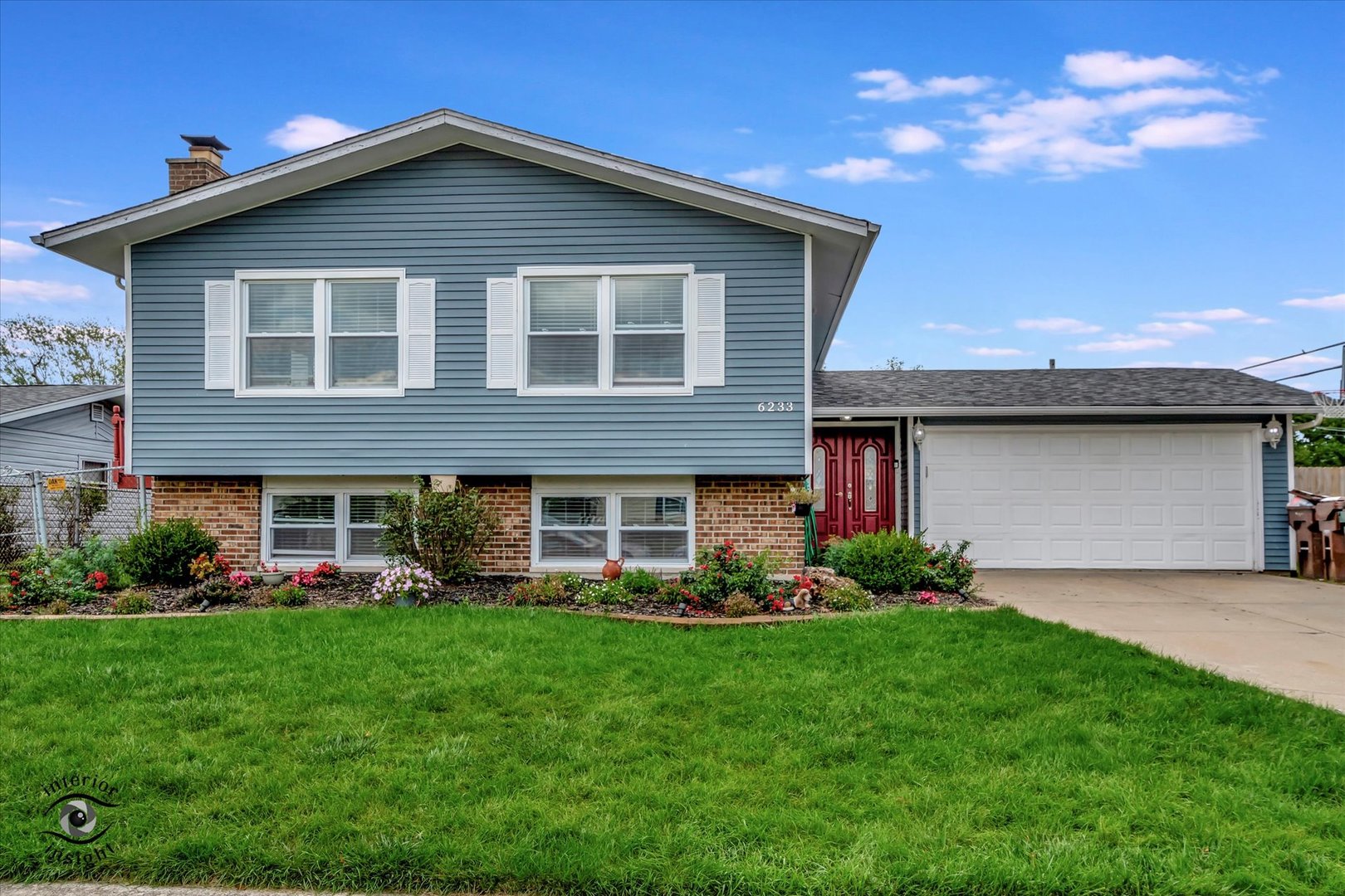 a front view of a house with a garden and plants