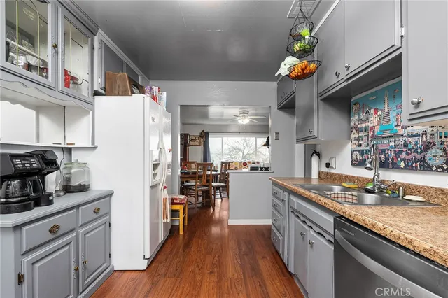 a kitchen with stainless steel appliances granite countertop a refrigerator a stove and a wooden floors