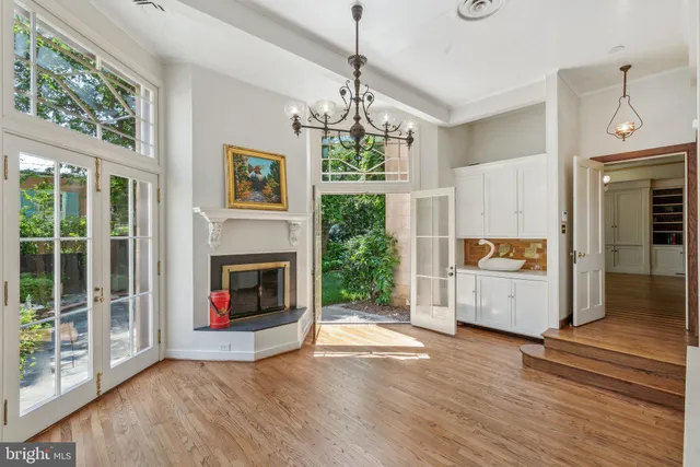 an empty room with windows and chandelier
