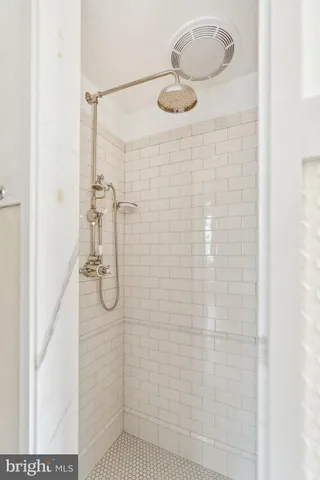 a view of an empty room with wooden floor fireplace and a window