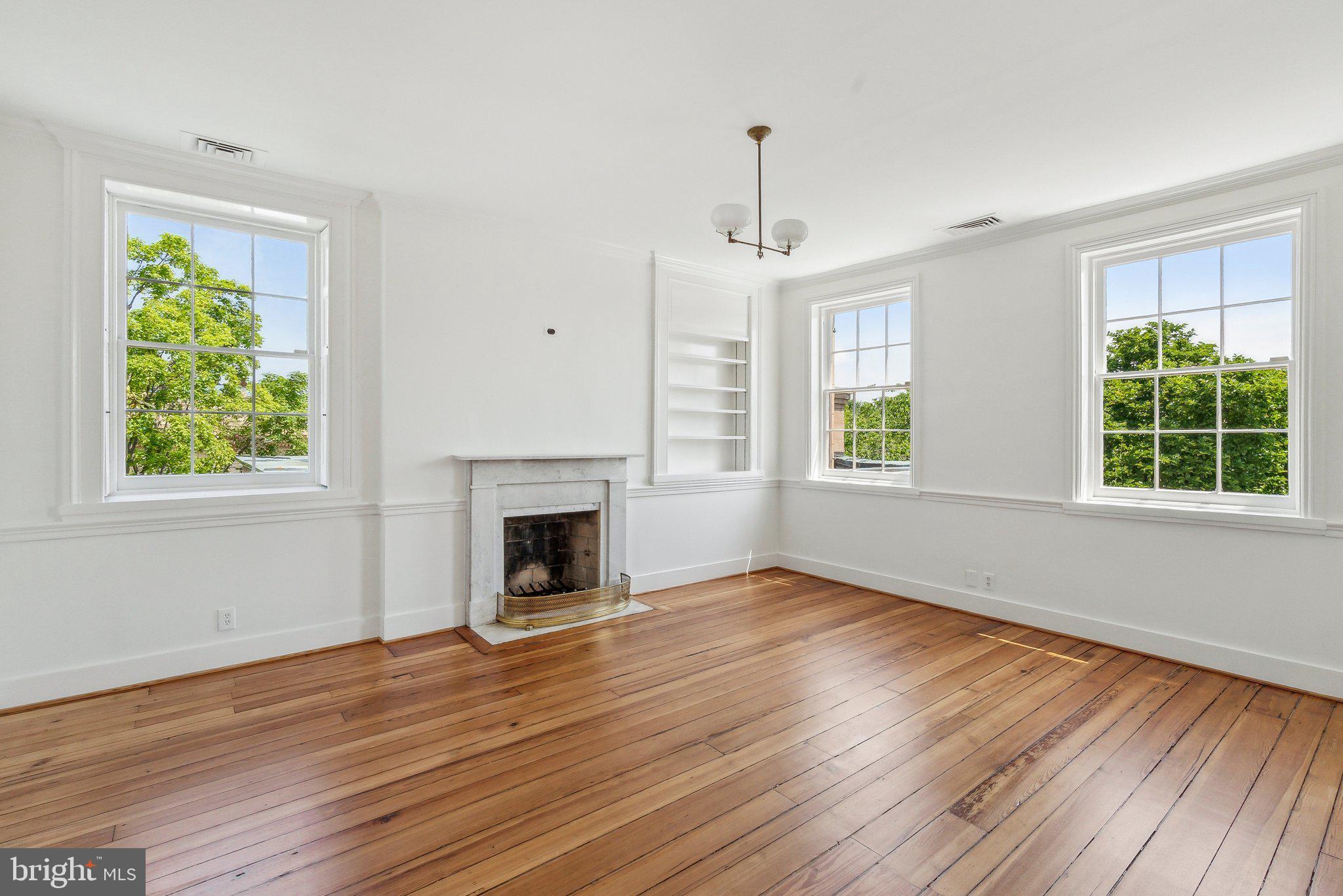 1527 35th Street Northwest Washington, DC 20007 - Photo 20 of 33 a view of an empty room with wooden floor fireplace and a window