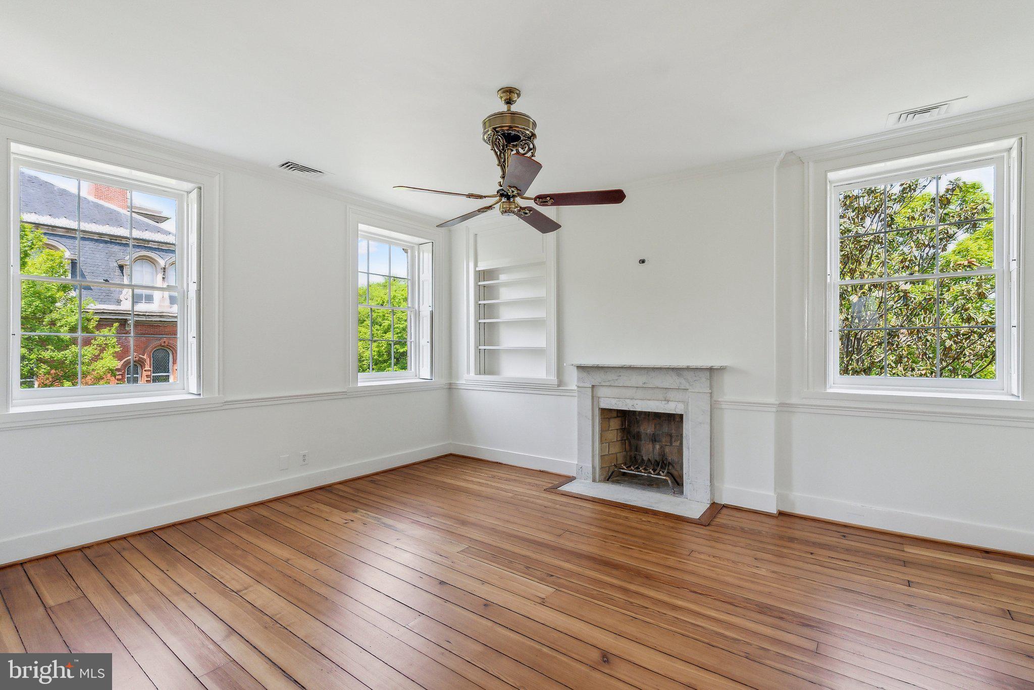 1527 35th Street Northwest Washington, DC 20007 - Photo 21 of 33 a view of an empty room with wooden floor fireplace and a window