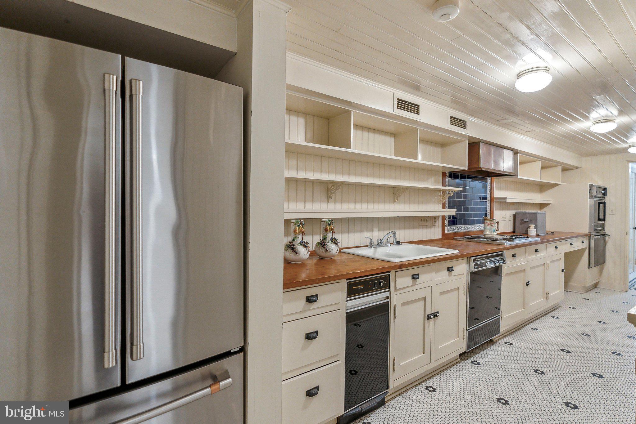 1527 35th Street Northwest Washington, DC 20007 - Photo 22 of 33 a kitchen with stainless steel appliances a refrigerator sink and cabinets