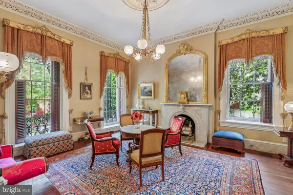 a living room with furniture a fireplace and a chandelier