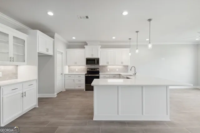 a kitchen with white cabinets and stainless steel appliances