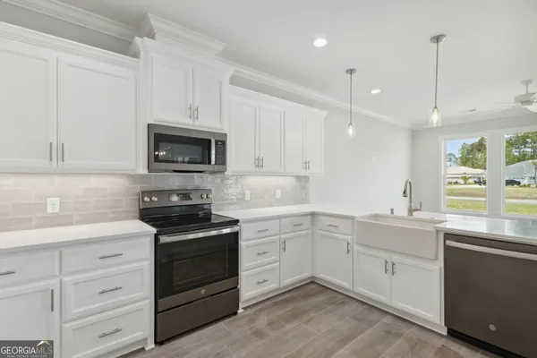 a kitchen with white cabinets stainless steel appliances and a sink