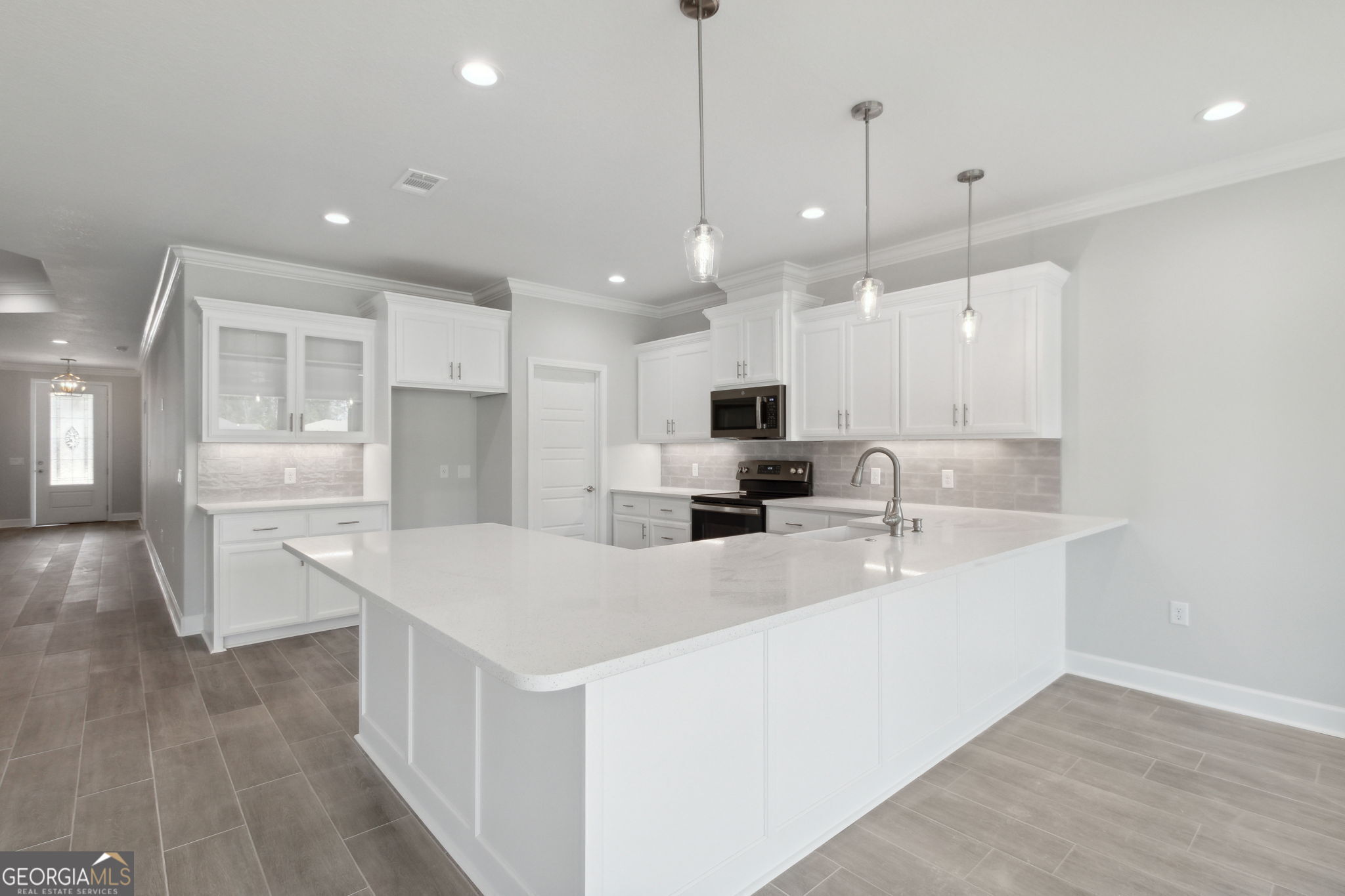 107 Green Turtle Court Kingsland, GA 31548 - Photo 15 of 39 a large white kitchen with kitchen island a sink a center island stainless steel appliances and a living room view