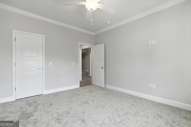 an empty room with a chandelier fan and closet area