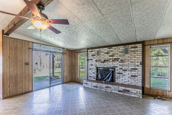 a view of an empty room with a fireplace and a window