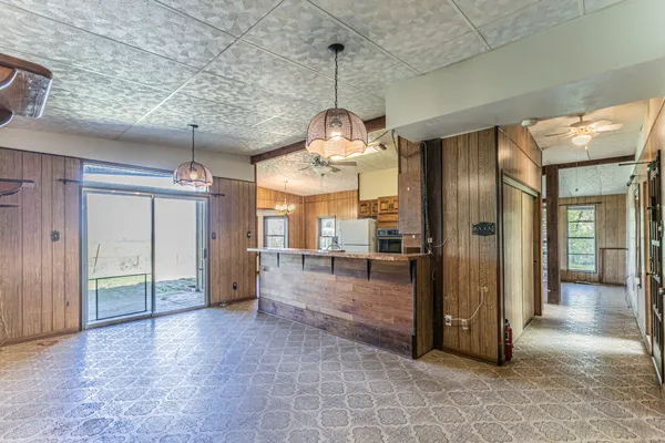 a view of a hallway with wooden floor and a kitchen