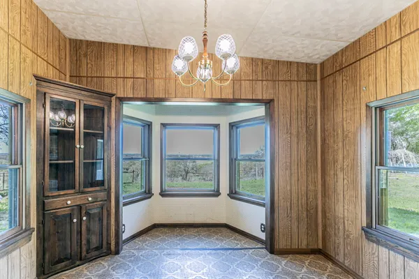 a room with chandelier and wooden floor