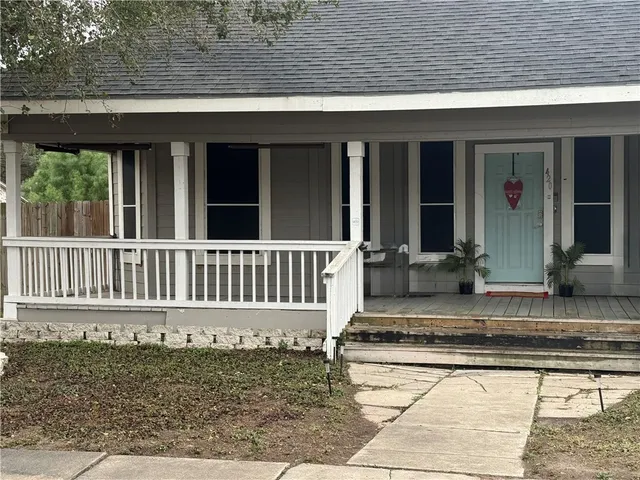 a view of a house with a small yard and wooden floor and fence