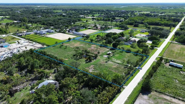 an aerial view of residential houses with outdoor space and trees