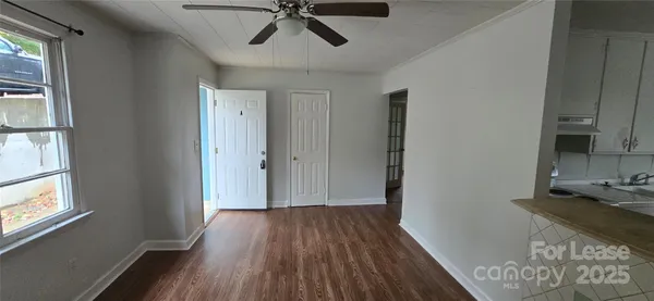 a view of a hallway with wooden floor and a window