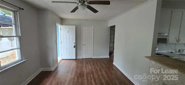 a view of a hallway with wooden floor and a window